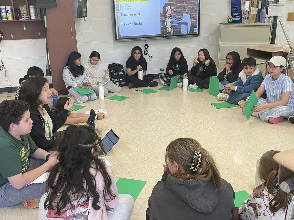 Spanish musical Club students sitting in a circle working on the script 