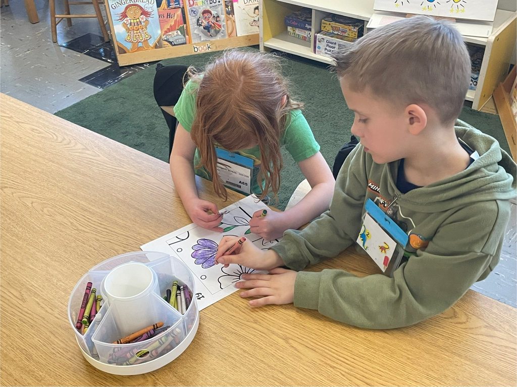 students coloring an earth day sign 