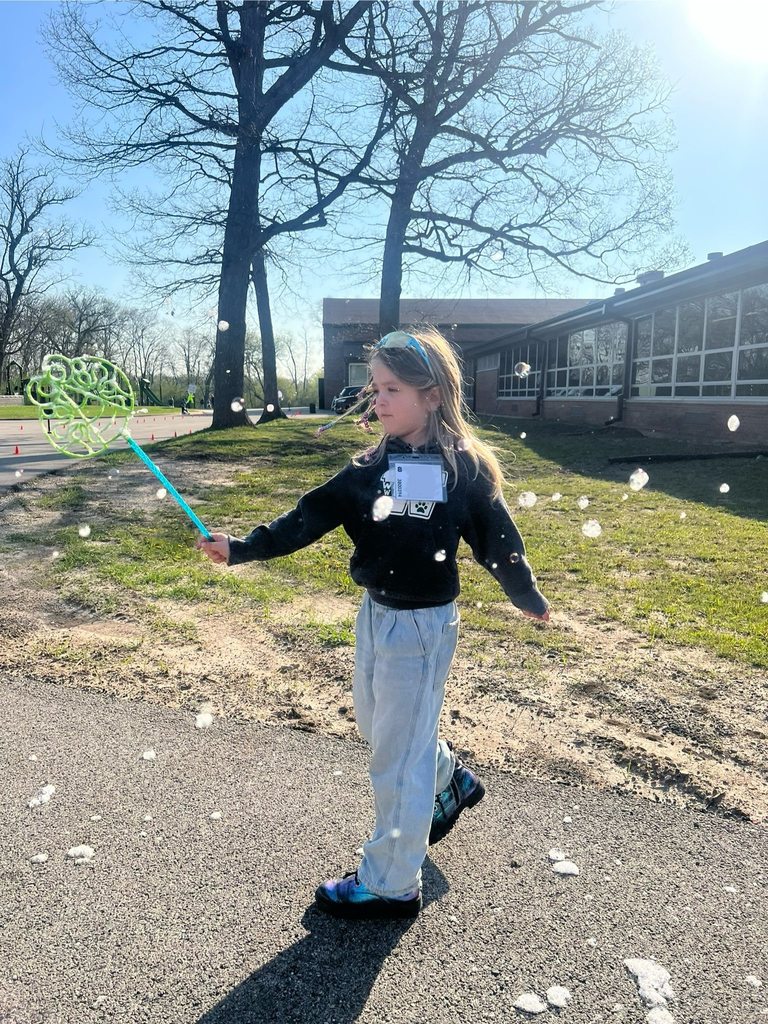 student playing with bubbles outside 