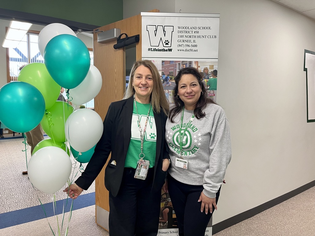 Two Woodland employees with balloons to welcome attendees April 2025