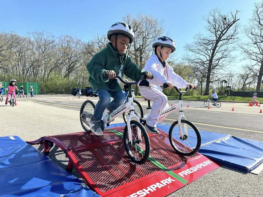 Primary Students on Bikes going over a little ramp 