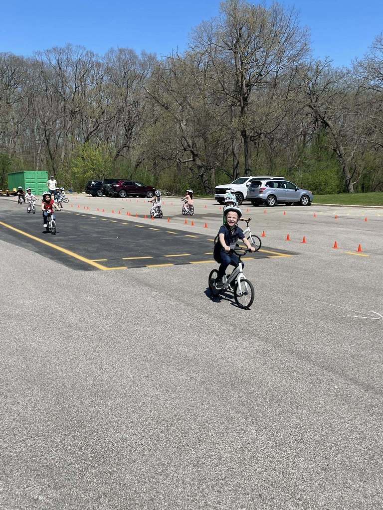 Primary students on bikes riding the circuit in the back lot 