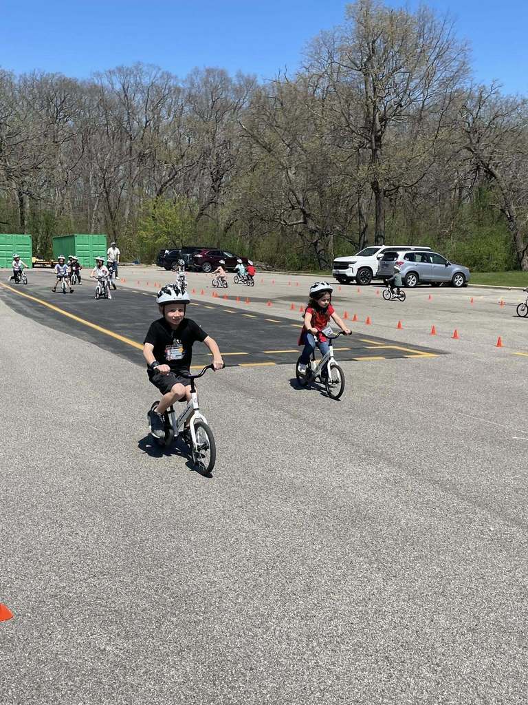 Primary students on bikes riding the circuit in the back lot 