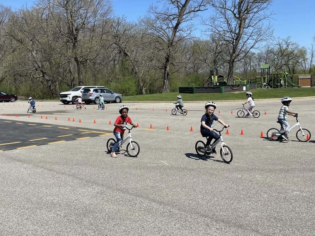 Primary students on bikes riding the circuit in the back lot 