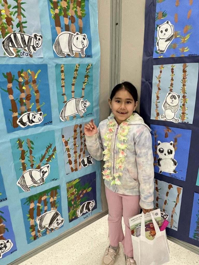 Student with their artwork on display 