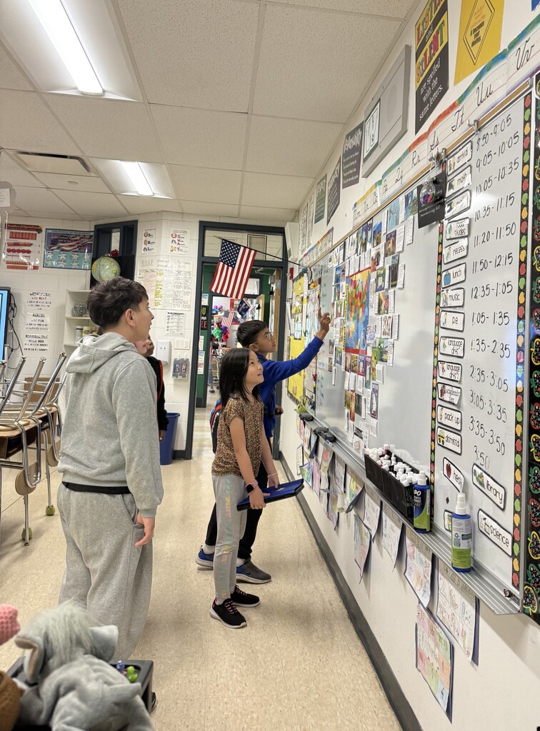 Students help Ms. Thomas create a display of the postcards they received from other states