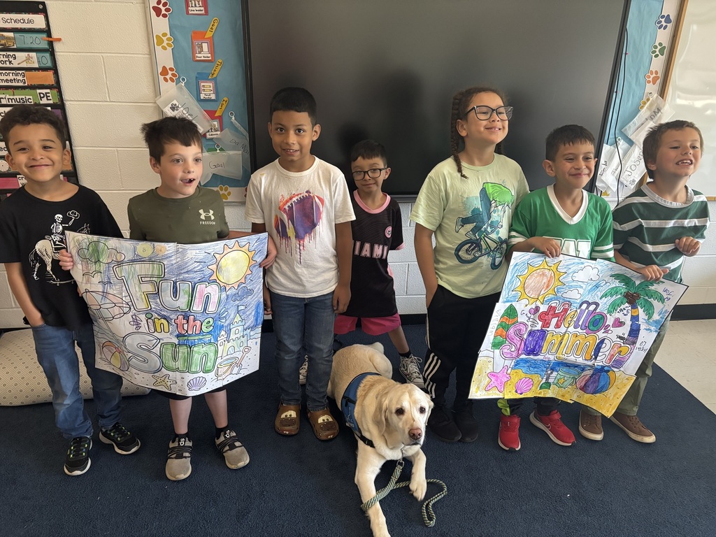Ms. Jennings - 1st Grade - Students pose with summer posters and Truett the Service Dog