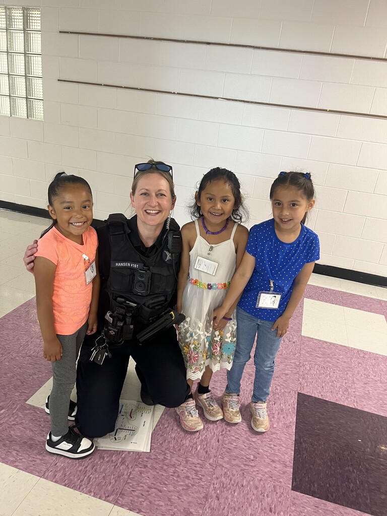 Woodland School Resource Officer Kelly Hansen smiles for a photo with 3 students