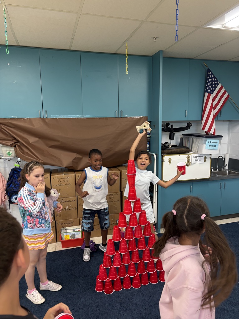 Students work together on a STEM challenge with cup stacking