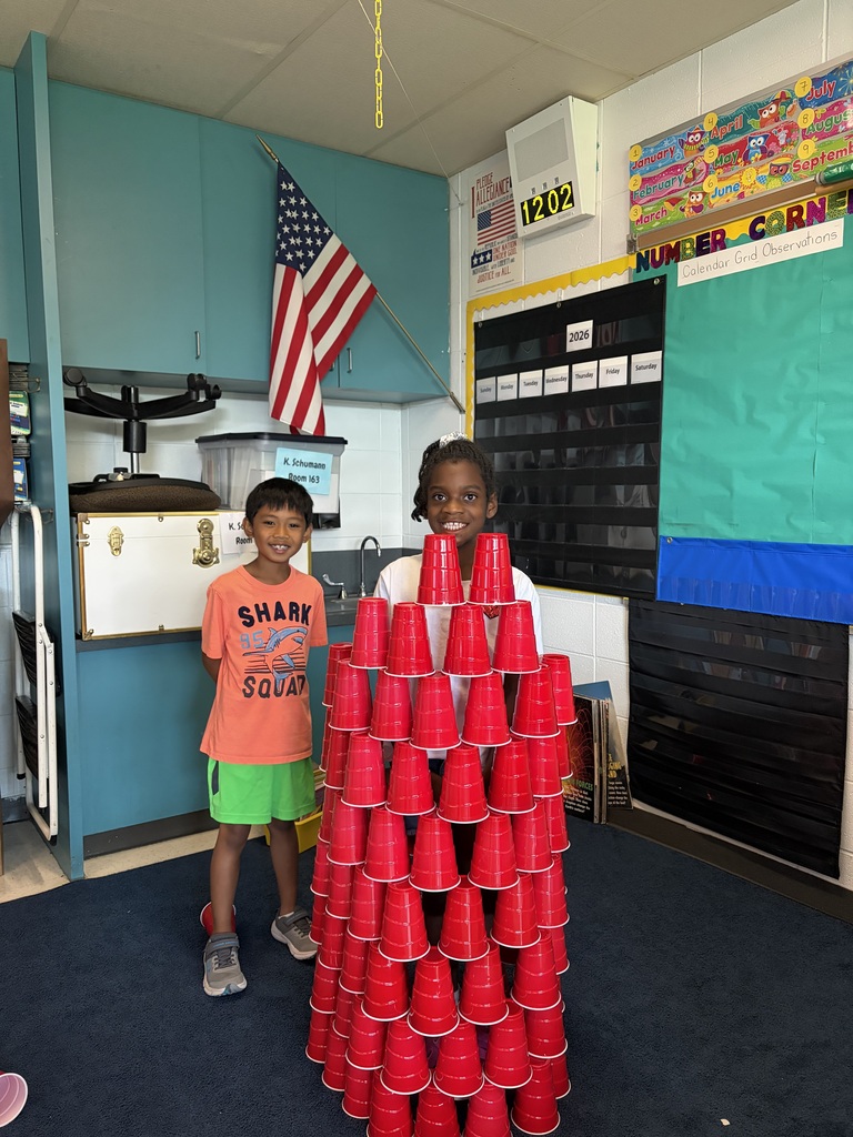 Students work together on a STEM challenge with cup stacking