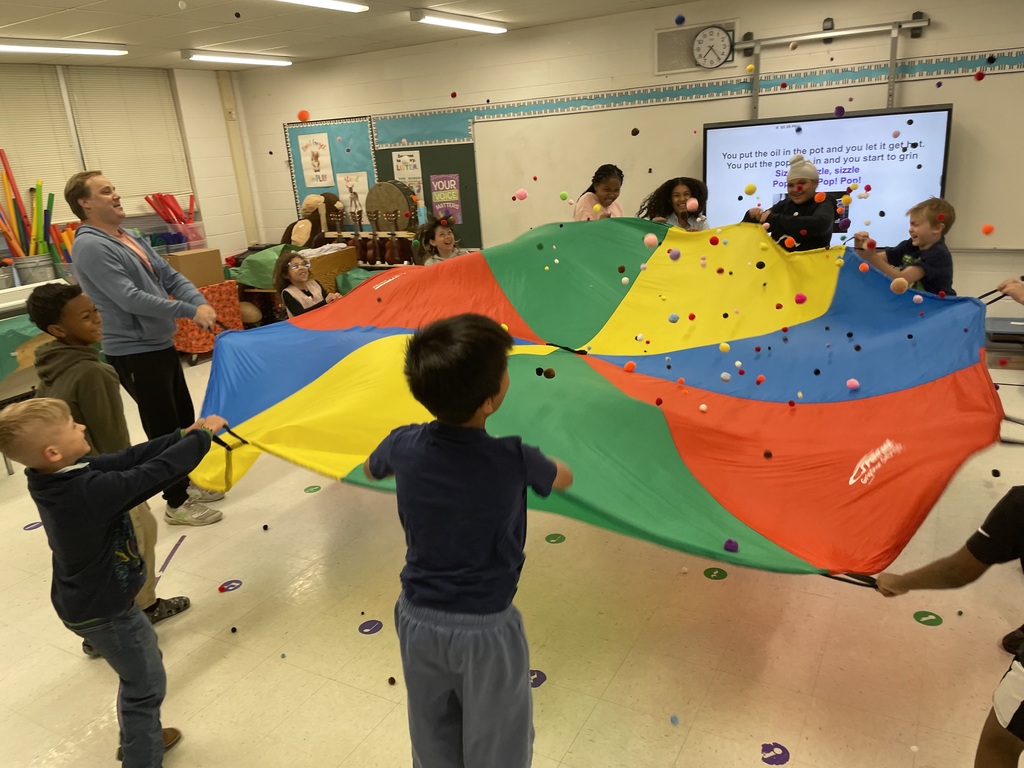 Summer classroom activities - students play with a parachute in Music