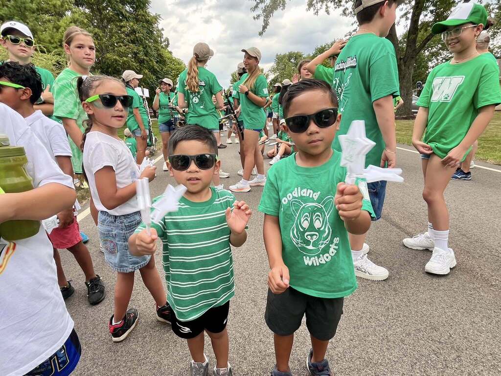 Woodland Students in green spirit wear and sunglasses ready to march in the parade