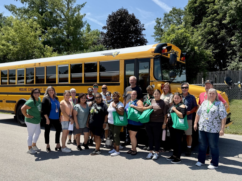Transportation Team Members pose for a photo in front of a bus on a sunny day in July 2026