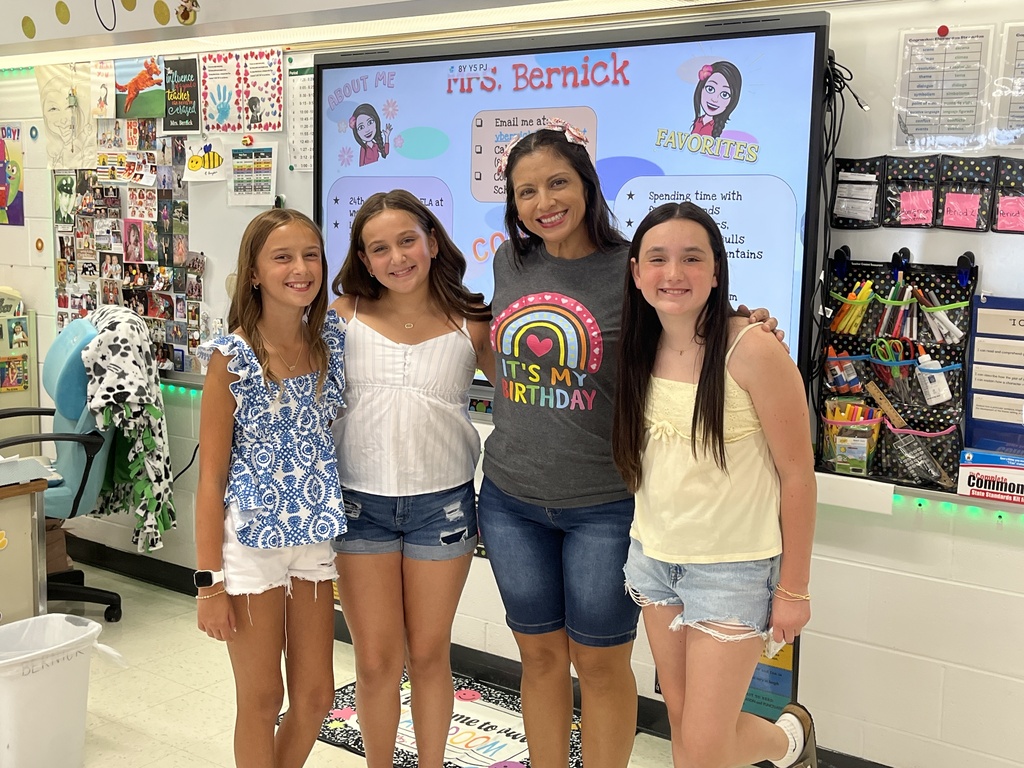 Three students pose with teacher at Sneak Peek, Aug. 2026