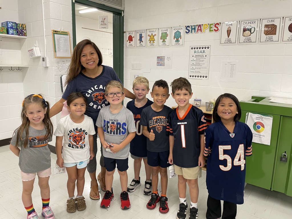 Teacher and a group of students pose for a picture proudly wearing Chicago Bears spirit wear