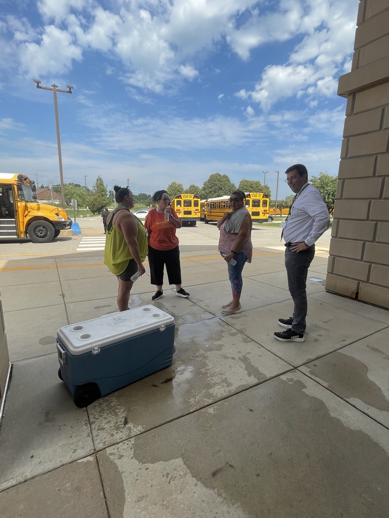 Passing out cold water to bus drivers on a hot day