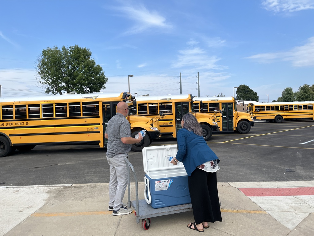 Passing out cold water to bus drivers on a hot day