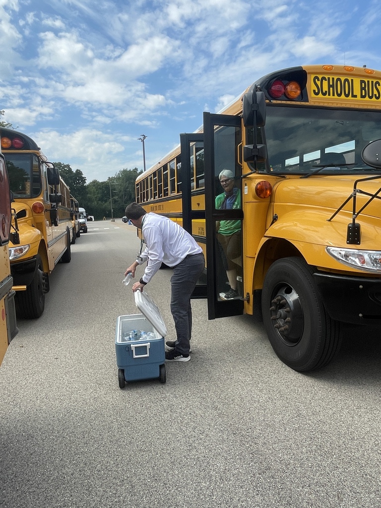 Passing out cold water to bus drivers on a hot day