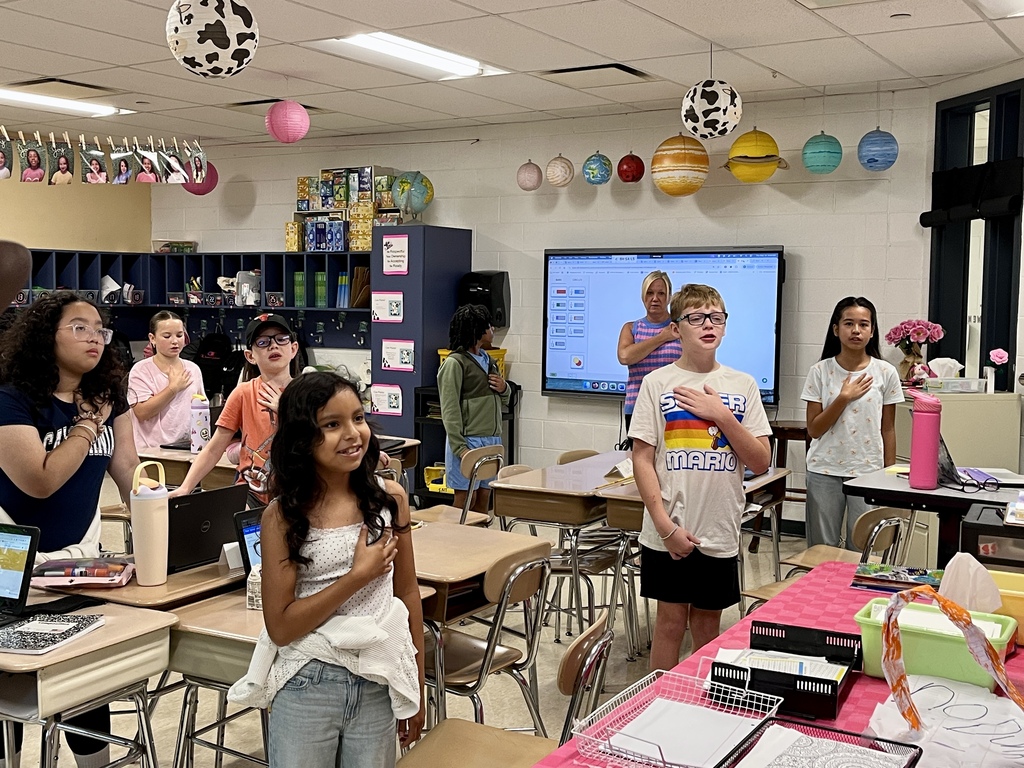 Students say the Pledge of Allegiance in their classroom
