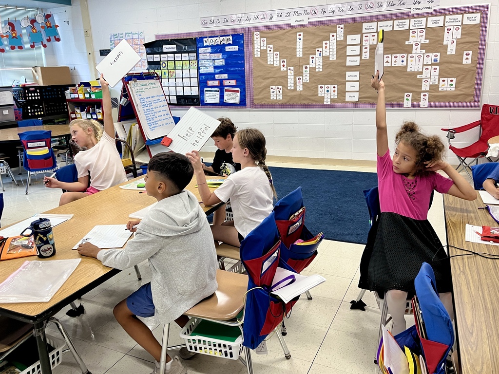 Students show their work on a dry erase board