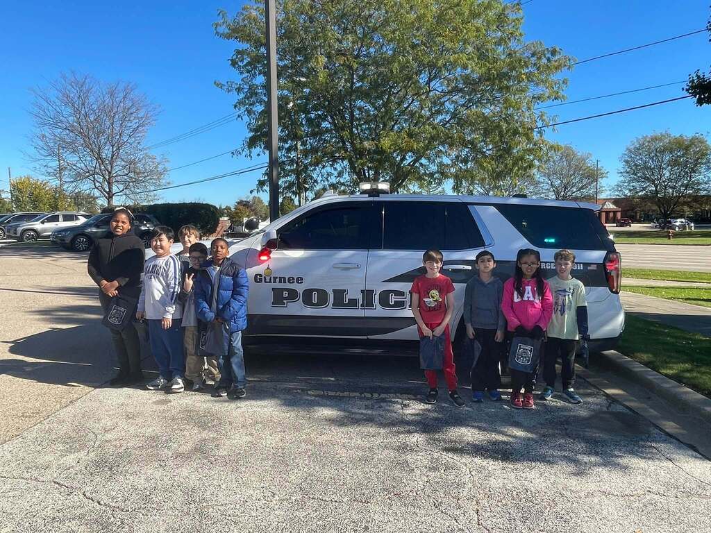 students in front of a squad car