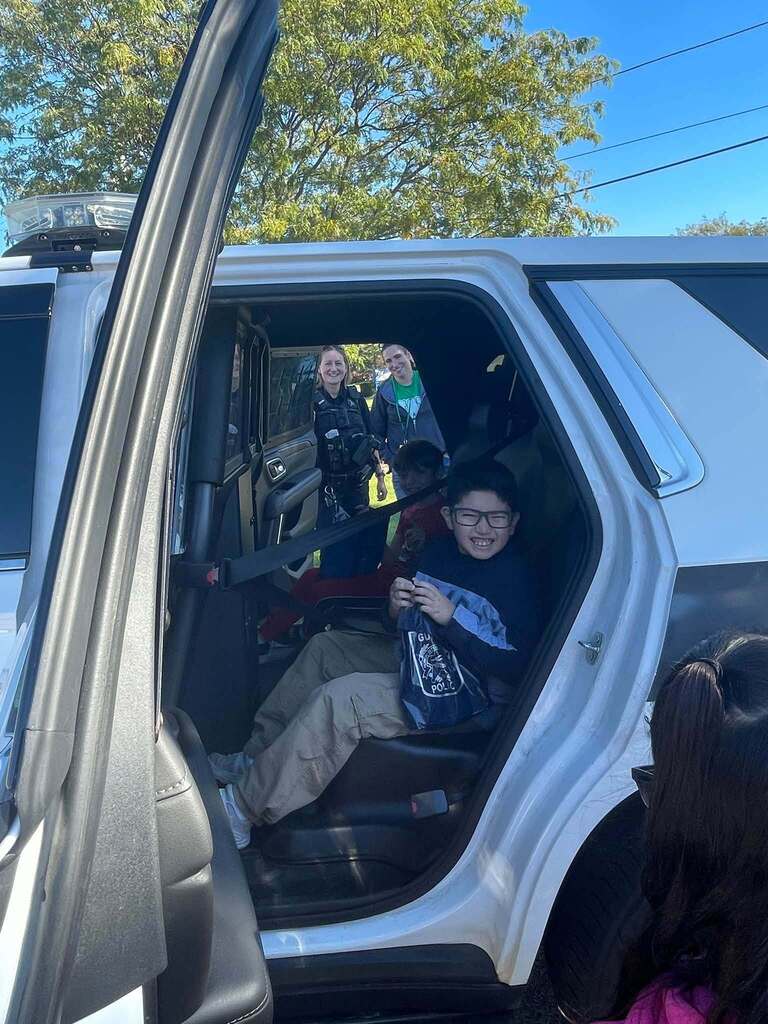 students in a squad car 