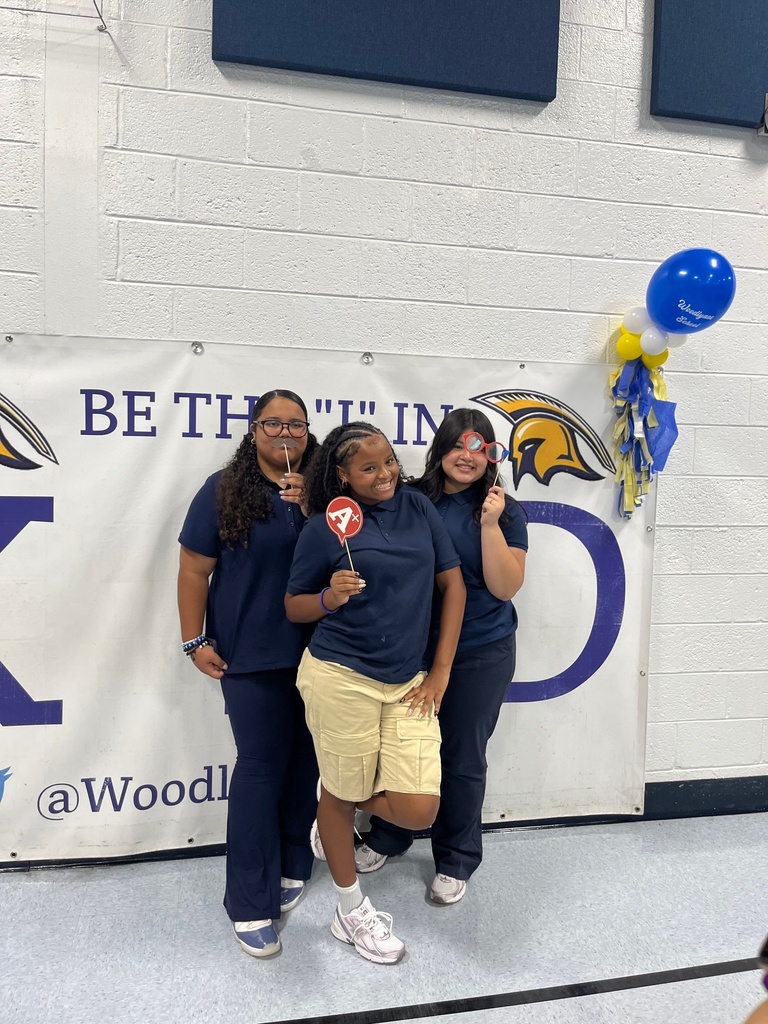 three student posing with props for picture
