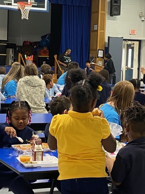 students eating lunch being entertained by a student singing
