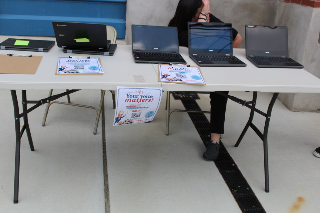 Computers on a table with QR code to take survey