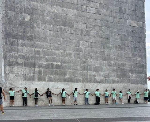 students lined up against the washington monument base