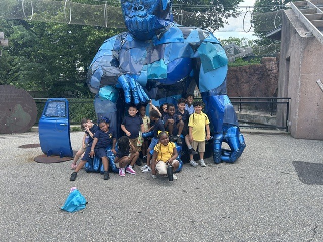 students in front of the blue monkey statue in the philadelphia zoo