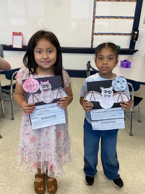 two students holding their bat project