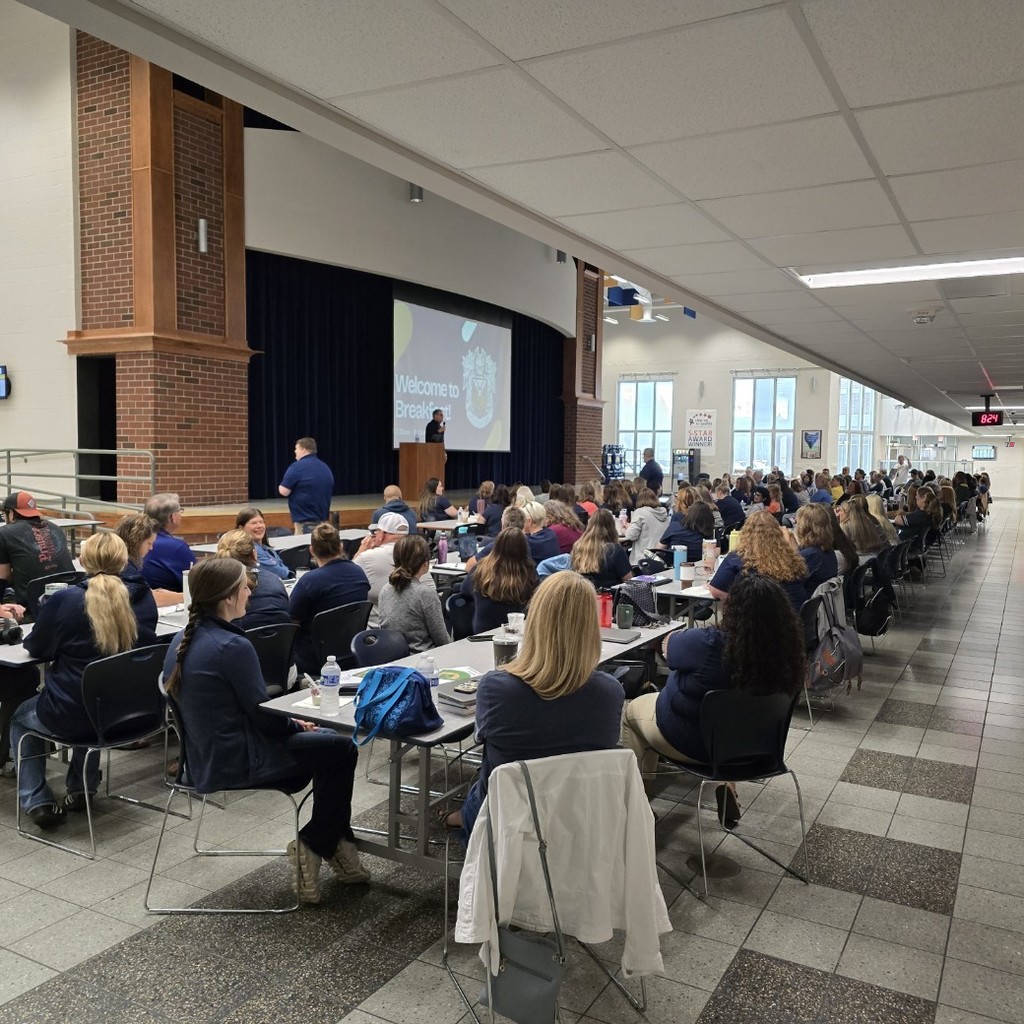 Staff sitting in the cafetorium listening to Mr. Mock speak
