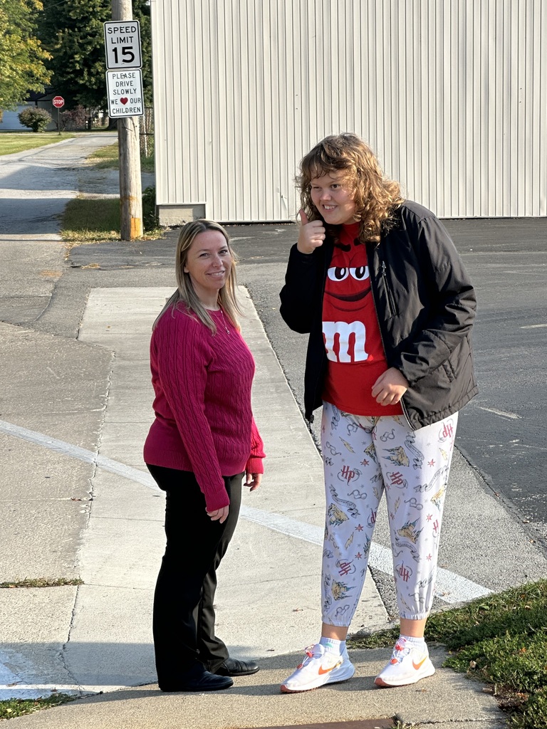 A student and an aide posing for a picture while out in the community helping to clean up.