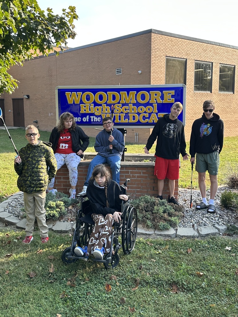 Mr. McCarthy's students posing in front of the Woodmore High School sign