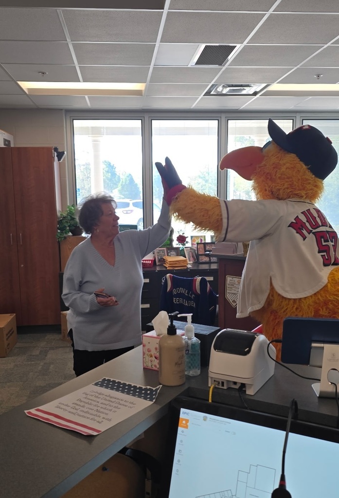Muddy high-fiving Middle School Secretary, Mrs. Harmon.
