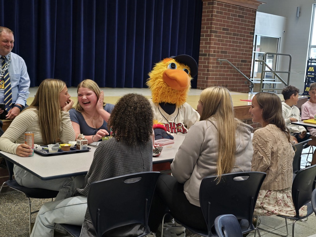 Muddy sitting at a lunch table with some students
