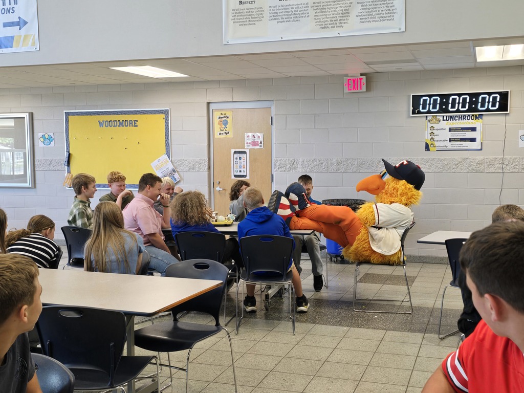 Muddy sitting with his feet up on the table with a group of students at lunch.