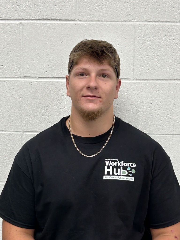 Bailey Jendrzejak poses for a picture with a black Ottawa County Workforce Hub t-shirt on!