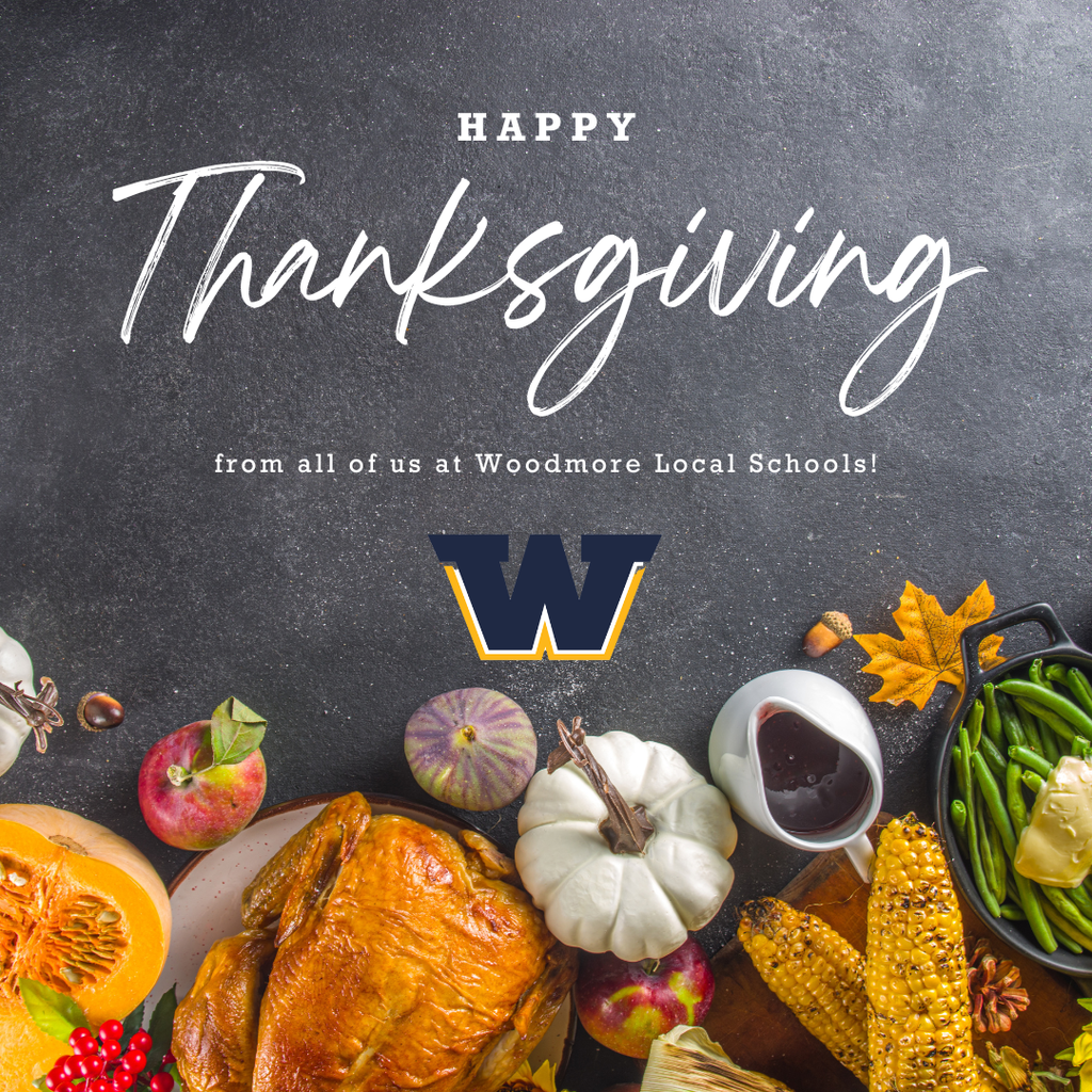 A gray table with Thanksgiving foods at the bottom of the image. The words "Happy Thanksgiving from all of us at Woodmore Local Schools!" in white writing across the top of the image. The Woodmore W is underneath the writing.