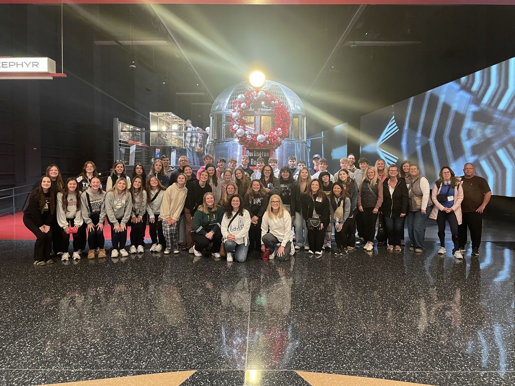 The high school choir, along with chaperones and Mrs. Coil, posing for a picture inside the main lobby of the Science and Industry Museum.