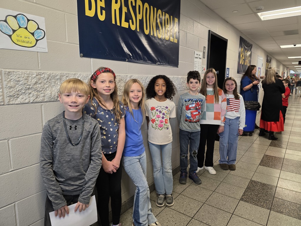Our Fourth Grade Student Council were the servers today! They pose for a picture on the back wall of the cafetorium.