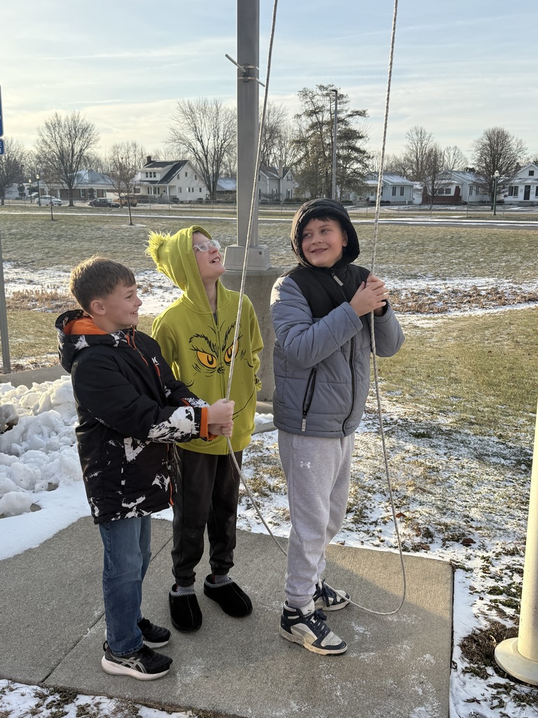 Our three students working together to raise the flag by pulling on the rope pulley.