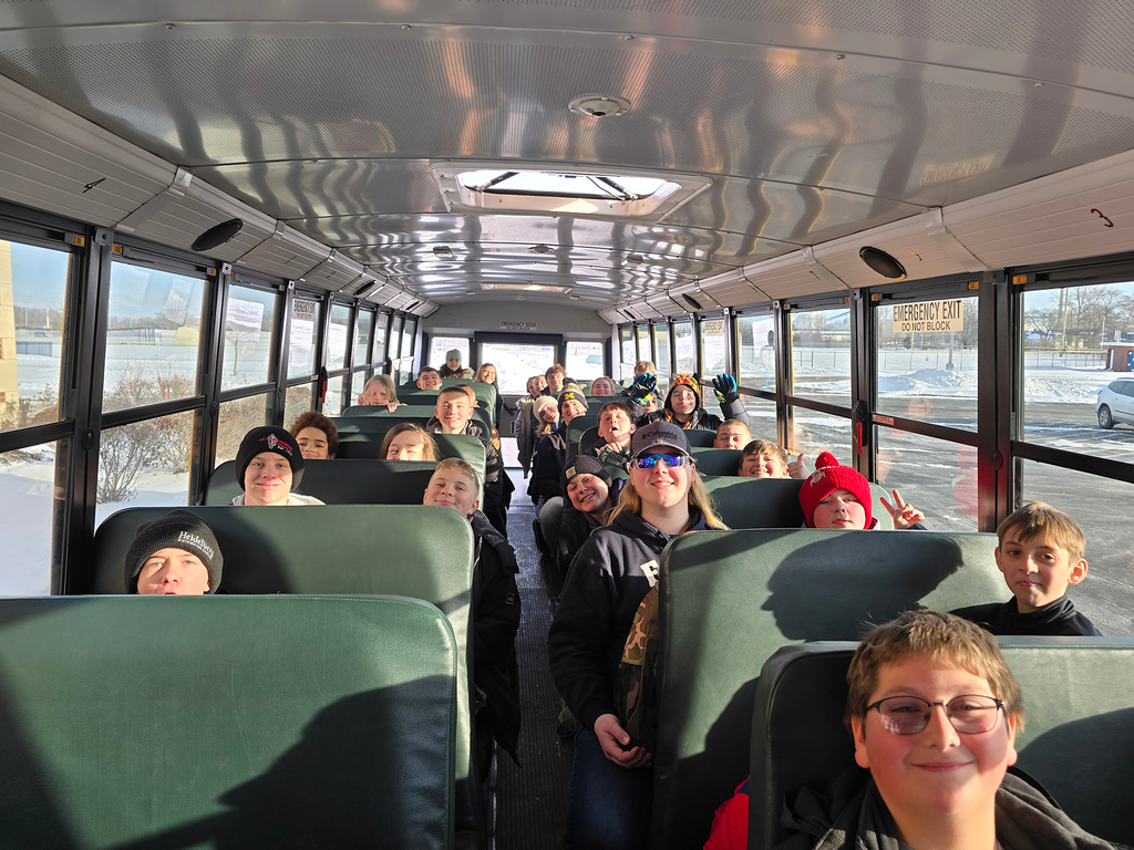 The sixth grade boys and their high school cabin leaders pose for a picture on their school bus as they prepare to leave for sixth grade camp