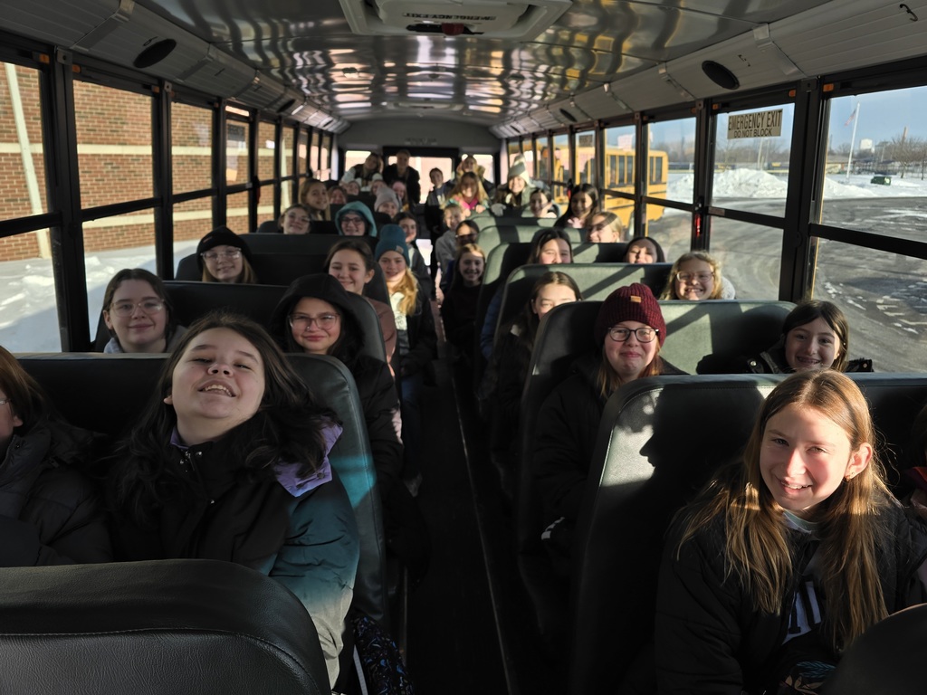 The sixth grade girls and their high school cabin leaders pose for a picture on their school bus as they prepare to leave for sixth grade camp