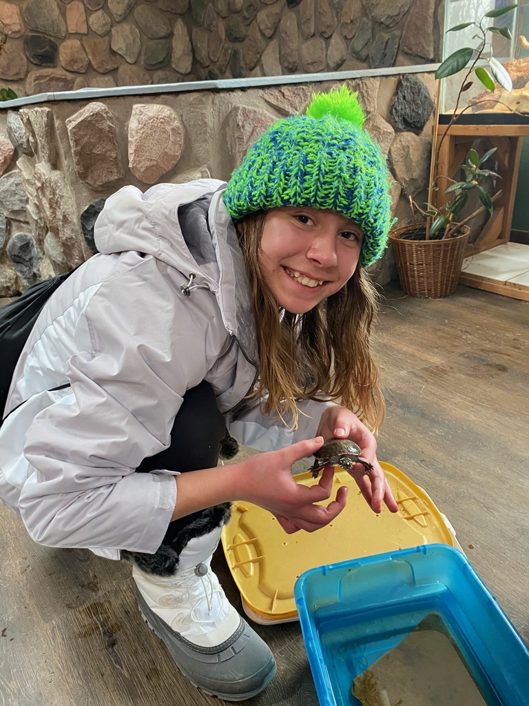 A sixth grade student holds a turtle during a lesson