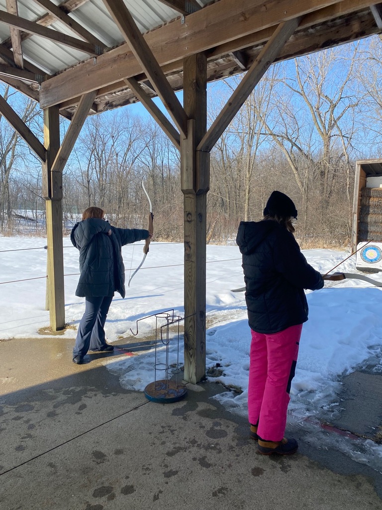 Two sixth grade students practice their archery skills on the range (in the snow!)