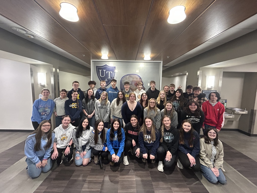 Anatomy and Physiology students pose for a picture in front of a sign that says "UT"