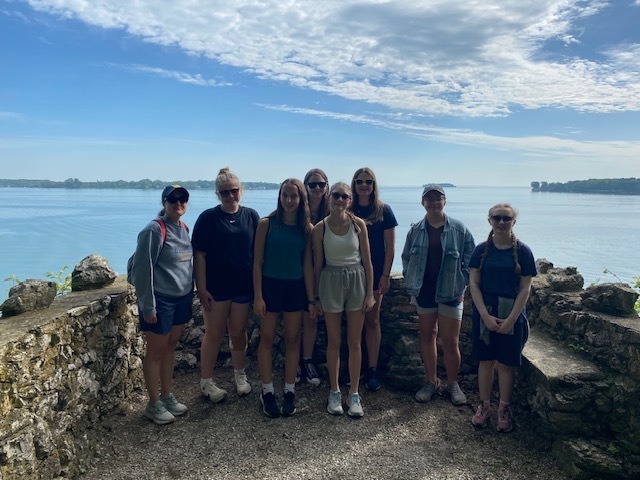 Students and a teacher pose for a picture on an overlook of Lake Erie.