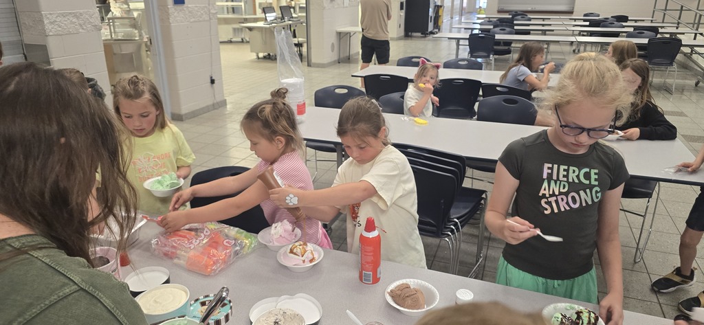 Students walk through a line to create their ice cream sundaes.